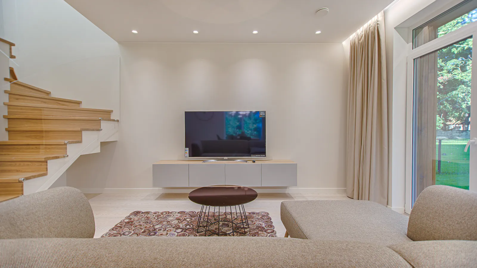 A sofa facing a large TV in a modern living room